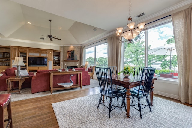 dining space featuring plenty of natural light, wood finished floors, crown molding, vaulted ceiling, and ceiling fan