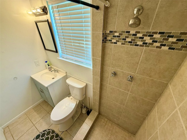 full bath with toilet, tiled shower, vanity, and tile patterned flooring
