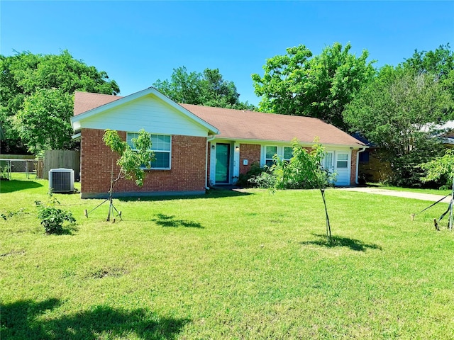 ranch-style house with brick siding, fence, central AC, concrete driveway, and a front yard