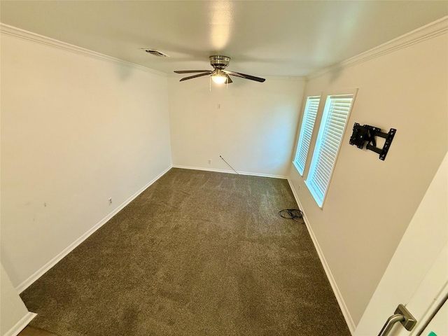 spare room with ceiling fan, crown molding, baseboards, and dark carpet