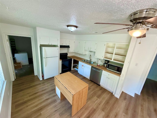 kitchen featuring a textured ceiling, light wood finished floors, stainless steel appliances, and a sink