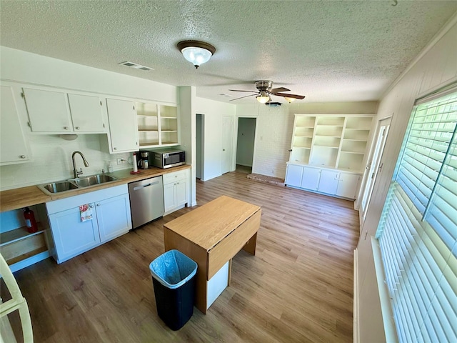 kitchen featuring a sink, open shelves, stainless steel appliances, white cabinetry, and visible vents