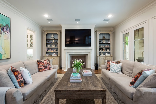 living area featuring a fireplace, ornamental molding, recessed lighting, and wood finished floors