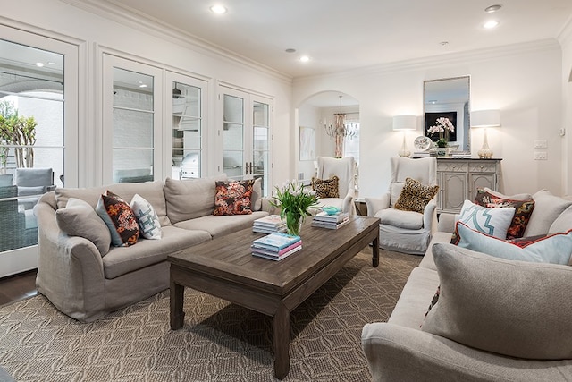 living area featuring ornamental molding, arched walkways, plenty of natural light, and wood finished floors