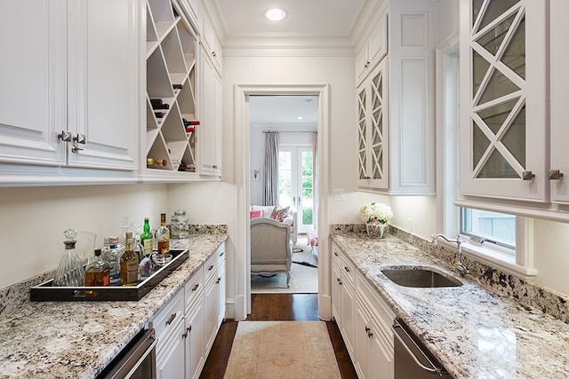 kitchen with glass insert cabinets, a sink, open shelves, crown molding, and white cabinets