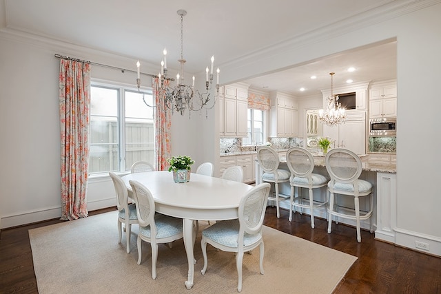 dining area with a chandelier, ornamental molding, dark wood-type flooring, and recessed lighting