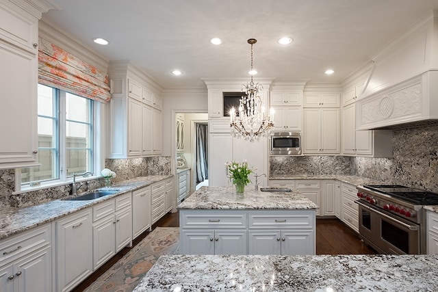 kitchen featuring stainless steel appliances, an inviting chandelier, a sink, and tasteful backsplash