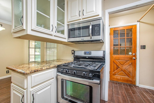 122 Big Bend Blvd, Waxahachie, TX 75165 - kitchen featuring appliances with stainless steel finishes, dark wood-style floors, baseboards, glass insert cabinets, and ornamental molding