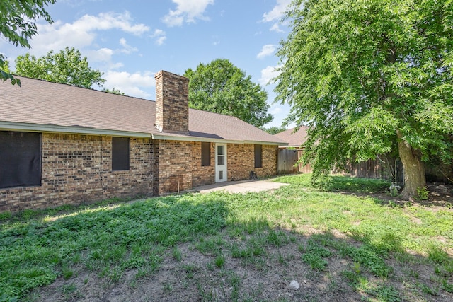 122 Big Bend Blvd, Waxahachie, TX 75165 - back of house featuring a chimney, fence, brick siding, and a patio