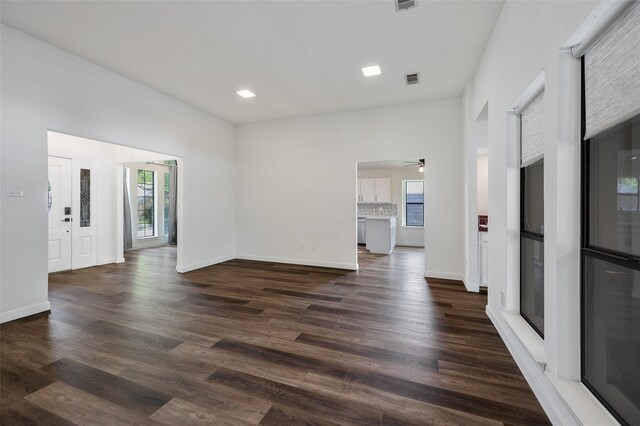 1413 Pecan Creek Dr, Garland, TX 75044 - unfurnished living room with baseboards, a ceiling fan, a healthy amount of sunlight, and dark wood-type flooring
