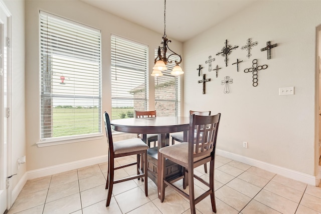 dining area featuring a chandelier, baseboards, and light tile patterned floors