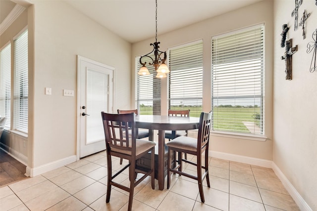 dining room featuring baseboards, a healthy amount of sunlight, an inviting chandelier, and light tile patterned floors