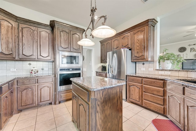 kitchen featuring appliances with stainless steel finishes, a center island, decorative backsplash, and light tile patterned floors