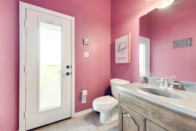 half bath with vanity, toilet, baseboards, and tile patterned floors