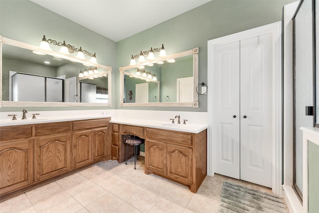 full bathroom with a sink, double vanity, a stall shower, and tile patterned flooring