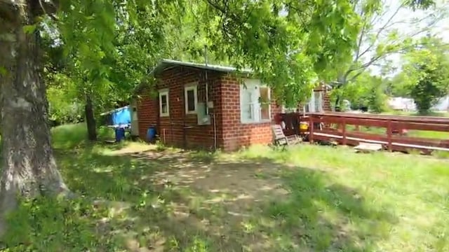 view of side of property featuring a deck and brick siding