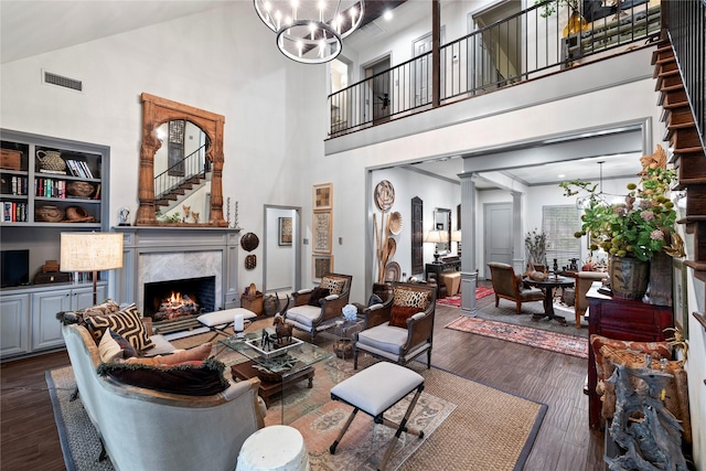 3517 Woods Blvd, Tyler, TX 75707 - living room with a high end fireplace, a towering ceiling, visible vents, dark wood-style flooring, and a notable chandelier