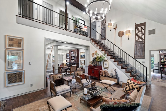 3517 Woods Blvd, Tyler, TX 75707 - living room featuring stairs, wood finished floors, visible vents, an inviting chandelier, and a high ceiling