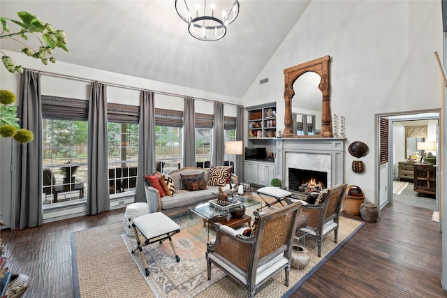 3517 Woods Blvd, Tyler, TX 75707 - living area with a high end fireplace, wood finished floors, high vaulted ceiling, visible vents, and an inviting chandelier