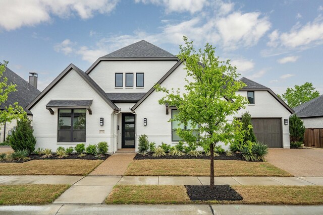 modern inspired farmhouse with concrete driveway, a garage, a shingled roof, and brick siding