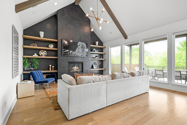 living room with beam ceiling, high vaulted ceiling, a chandelier, light wood finished floors, and a tiled fireplace