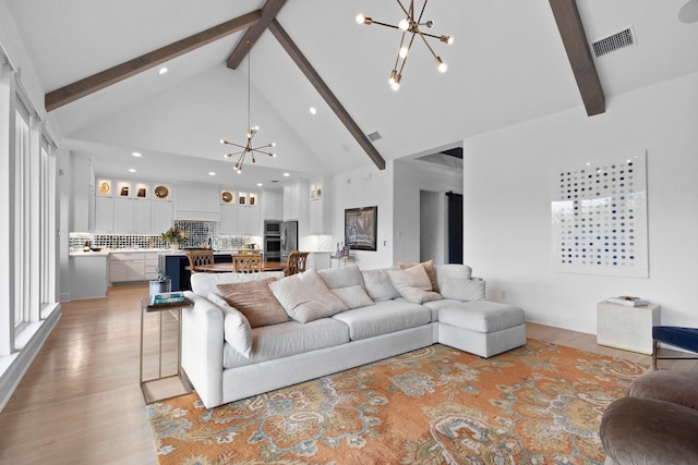 living area with a chandelier, visible vents, beamed ceiling, and high vaulted ceiling