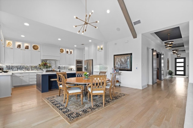 dining room with a notable chandelier, visible vents, a barn door, light wood-style floors, and recessed lighting