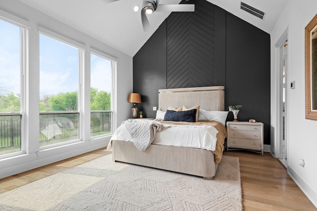 bedroom with vaulted ceiling, baseboards, visible vents, and wood finished floors