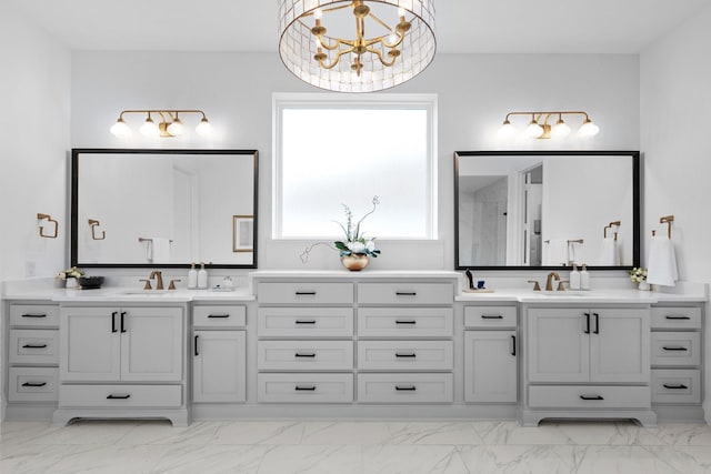 bathroom with a chandelier, marble finish floor, and vanity