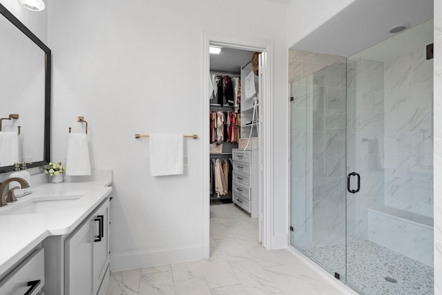 bathroom with baseboards, a shower stall, marble finish floor, vanity, and a spacious closet