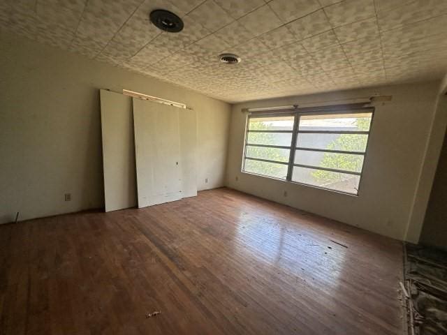 unfurnished room featuring visible vents and wood finished floors