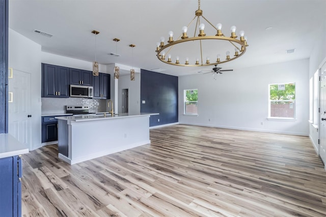 1014 Trinity St, Cleburne, TX 76031 - kitchen with appliances with stainless steel finishes, a chandelier, ceiling fan, light wood-type flooring, and blue cabinets