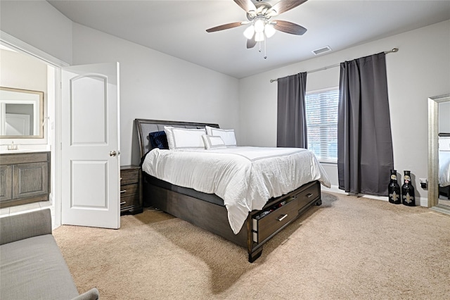 bedroom featuring visible vents, a ceiling fan, a sink, and light carpet