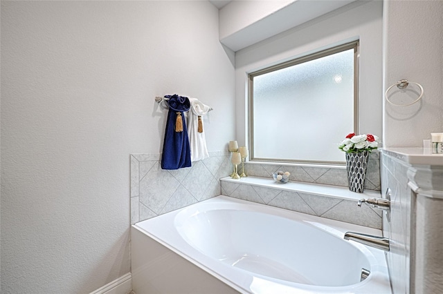 bathroom featuring a garden tub and a textured wall