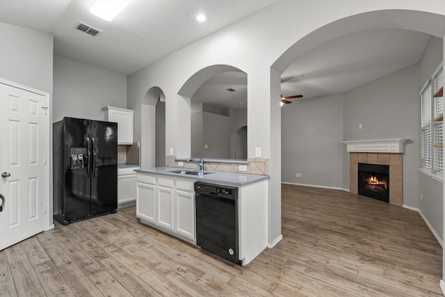 kitchen featuring ceiling fan, visible vents, a sink, black appliances, and light wood-type flooring