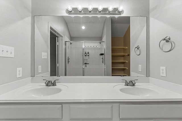 bathroom with double vanity, a stall shower, and a sink