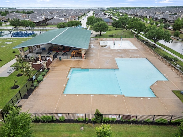 community pool featuring a patio, a residential view, and fence