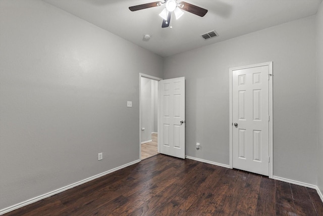 unfurnished bedroom with a ceiling fan, visible vents, wood finished floors, and baseboards