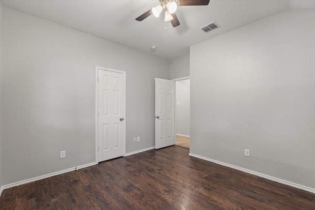 unfurnished bedroom featuring baseboards, a ceiling fan, visible vents, and dark wood-style floors