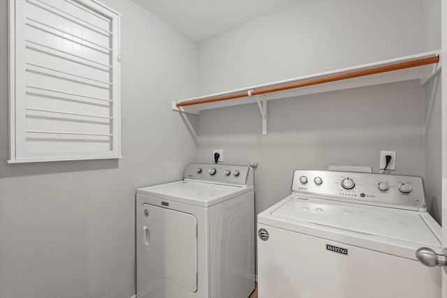 clothes washing area with washer and clothes dryer and laundry area