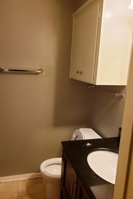 bathroom with toilet, tile patterned flooring, vanity, and baseboards