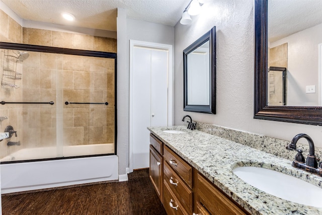 1200 Harwell Dr Unit 1924, Arlington, TX 76011 - bathroom with a textured ceiling, enclosed tub / shower combo, double vanity, and wood finished floors