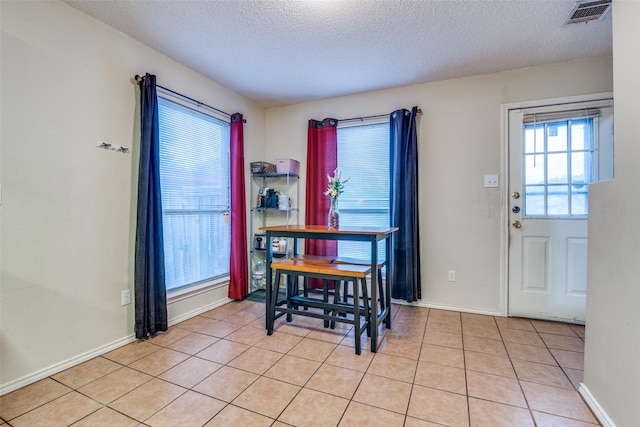 6109 Sasaki Way, Garland, TX 75043 - dining area featuring a textured ceiling, light tile patterned flooring, and baseboards