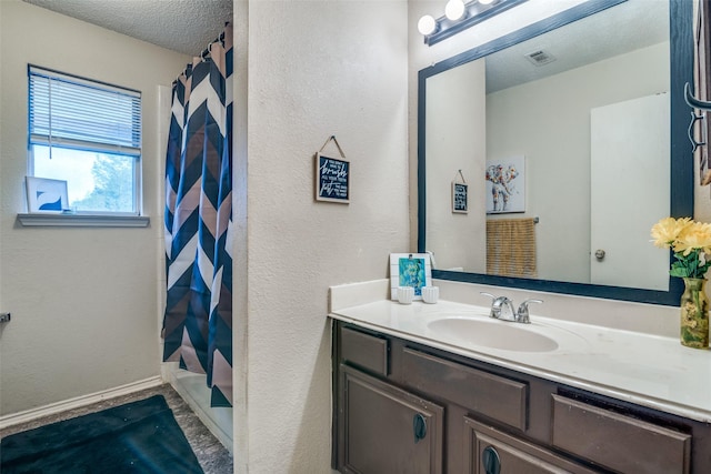 6109 Sasaki Way, Garland, TX 75043 - bathroom featuring vanity, a textured ceiling, and a textured wall