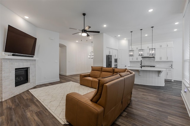 3509 Mescalbean Dr, Mckinney, TX 75071 - living room with dark wood finished floors, baseboards, a fireplace, and a ceiling fan