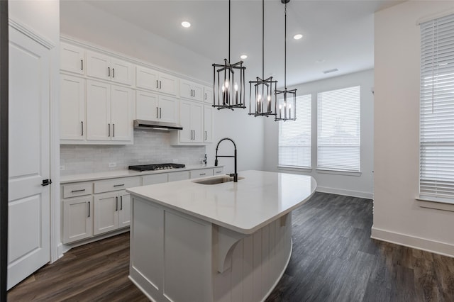 3509 Mescalbean Dr, Mckinney, TX 75071 - kitchen featuring a notable chandelier, under cabinet range hood, a sink, tasteful backsplash, and an island with sink