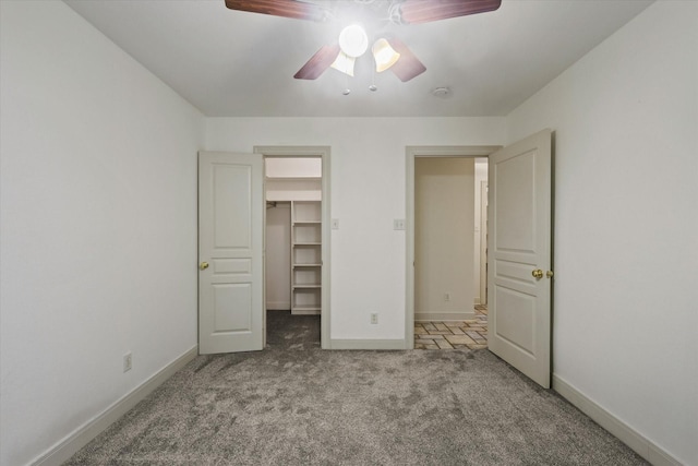 2020 Sauls Ln, Denton, TX 76209 - unfurnished bedroom featuring carpet flooring, a closet, a walk in closet, baseboards, and ceiling fan