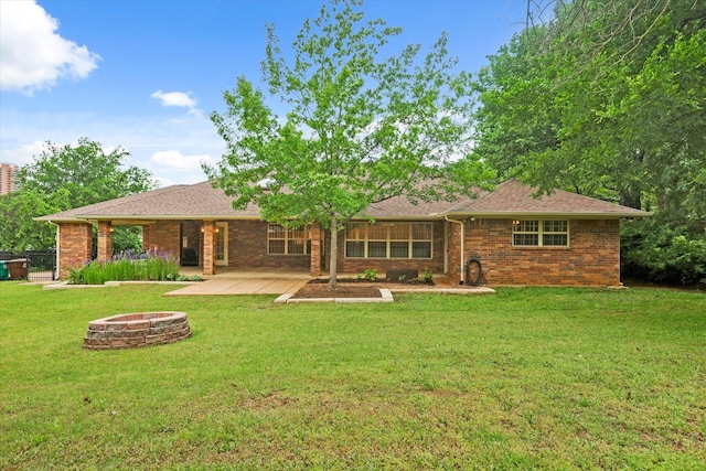 2020 Sauls Ln, Denton, TX 76209 - rear view of property featuring a patio, a fire pit, brick siding, and a lawn