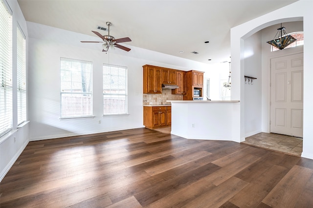 5204 Stoney Trl, Mckinney, TX 75072 - unfurnished living room featuring dark wood-type flooring, visible vents, ceiling fan, and arched walkways