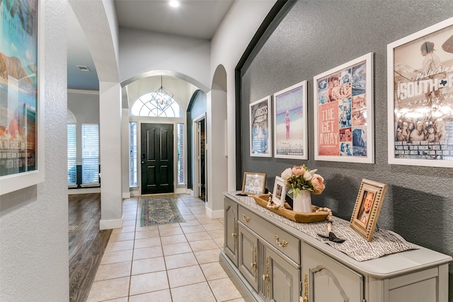 7916 Stansfield Dr, Fort Worth, TX 76137 - foyer with light tile patterned floors, baseboards, arched walkways, and a textured wall